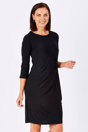 Model Perrie wearing size 10 of the Side Cross Dress in colour Black (Black), from the front, cropped image