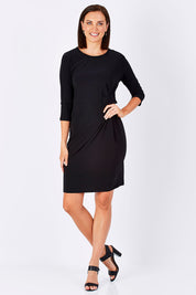 Model Perrie wearing size 10 of the Side Cross Dress in colour Black (Black), from the front, showing the whole outfit