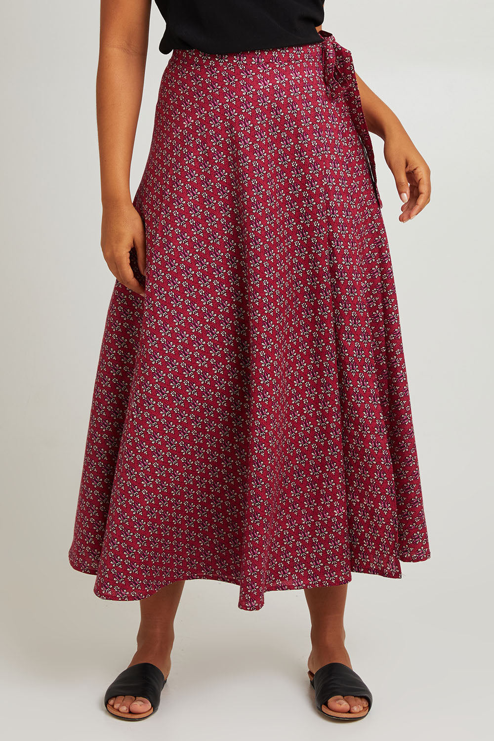 Model Olivia wearing size OneSize of the Grace Cotton Wrap Skirt in colour Corfu (Red), from the front, cropped image