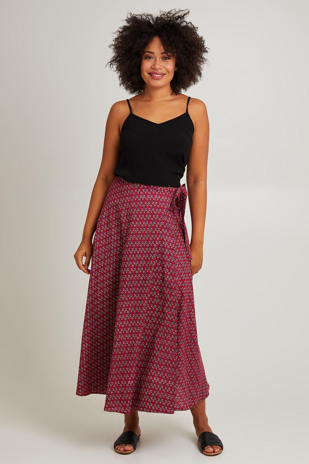 Model Olivia wearing size OneSize of the Grace Cotton Wrap Skirt in colour Corfu (Red), from the front, showing the whole outfit