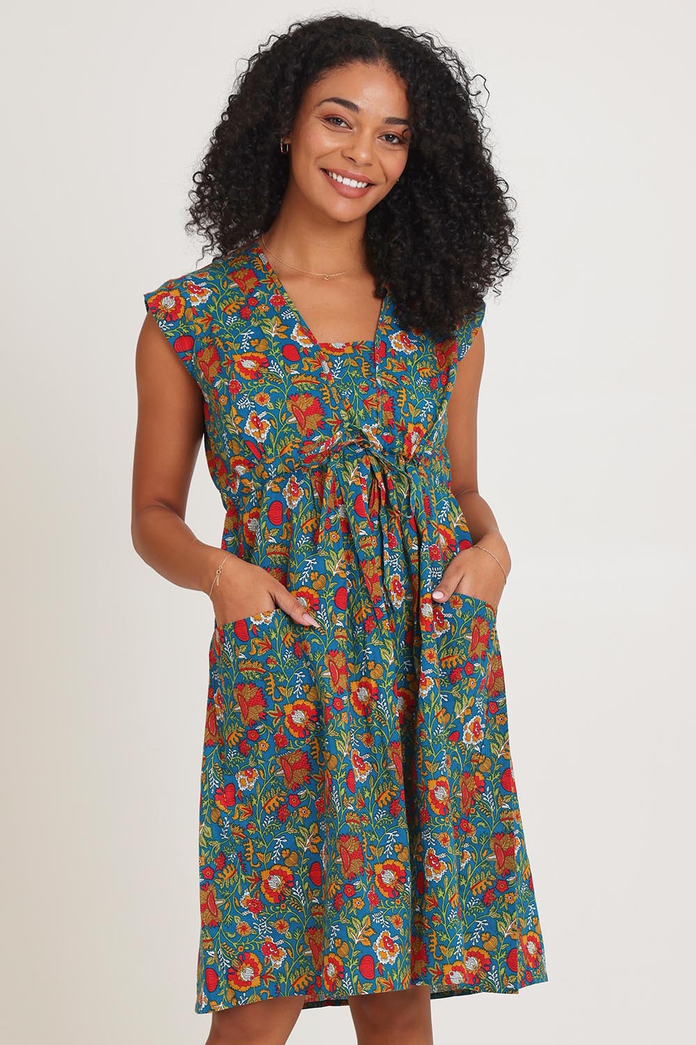 Model Ziara wearing size S of the Chrissie Cotton Tunic Dress in colour Valla, from the front, cropped image