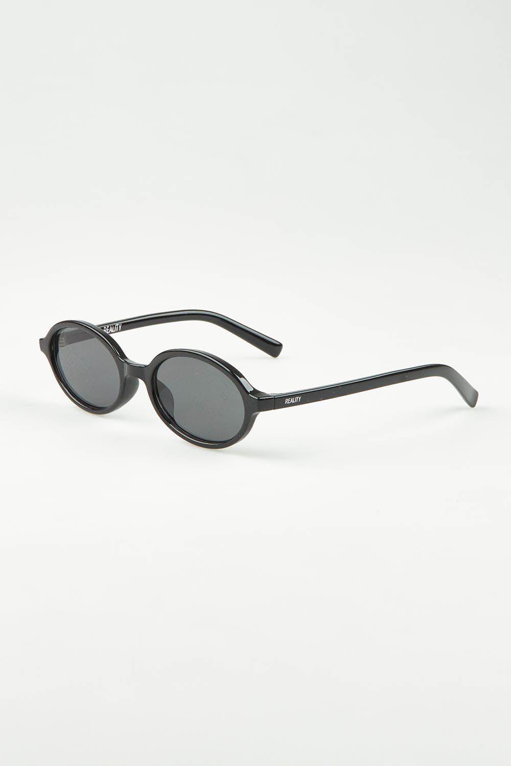 A model wearing The Bessette Sunglasses in colour Black (Black), from the front, showing the whole outfit