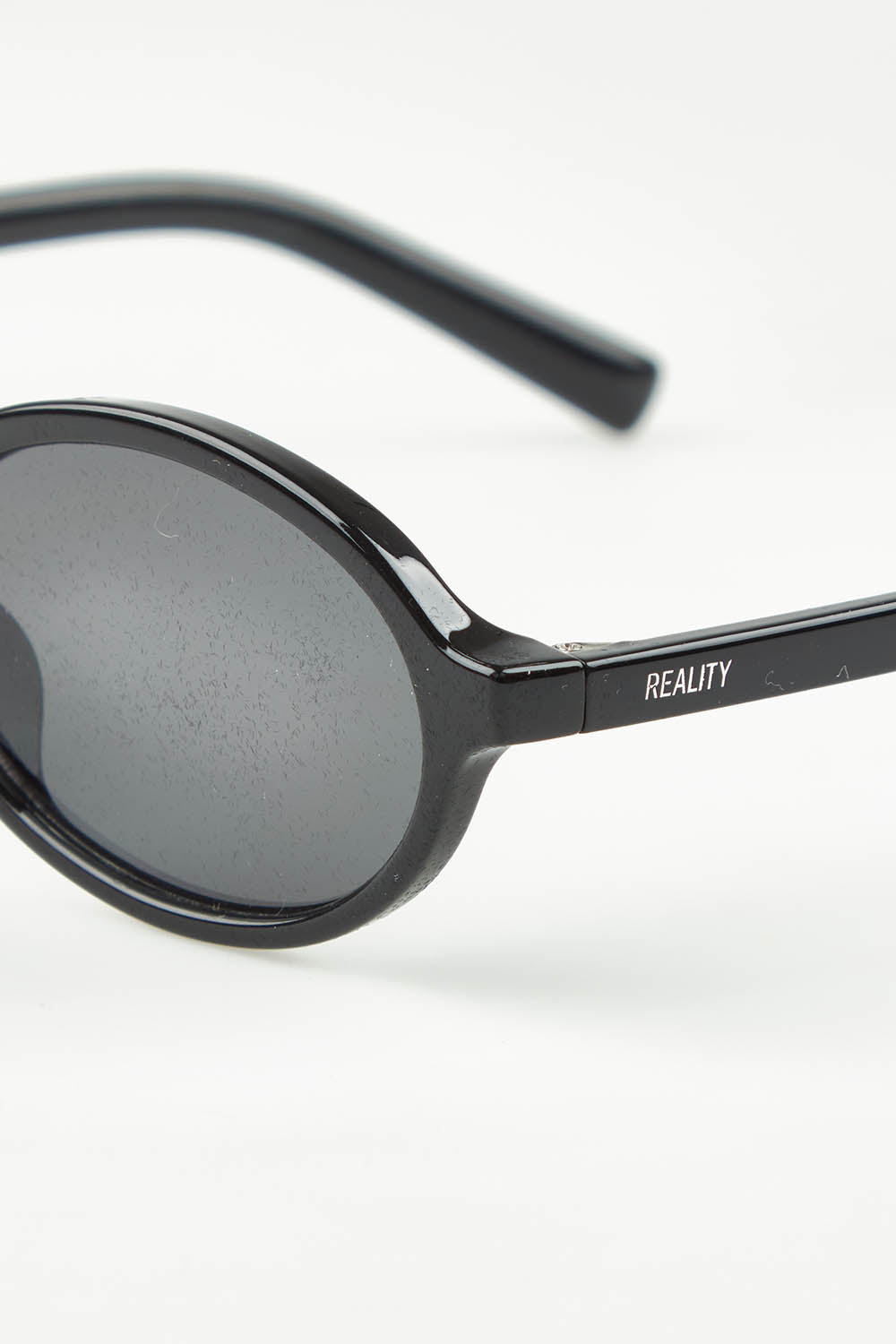 A model wearing The Bessette Sunglasses in colour Black (Black), from the front, showing the whole outfit