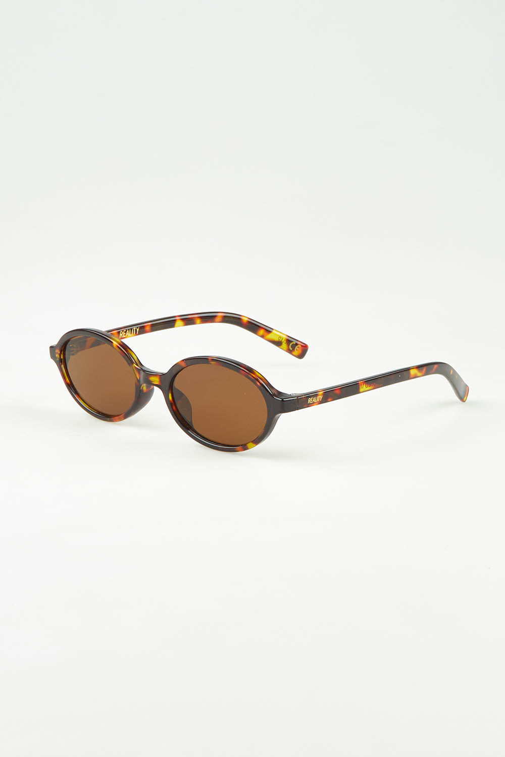 A model wearing The Bessette Sunglasses in colour Turtlebrwn, from the front, showing the whole outfit