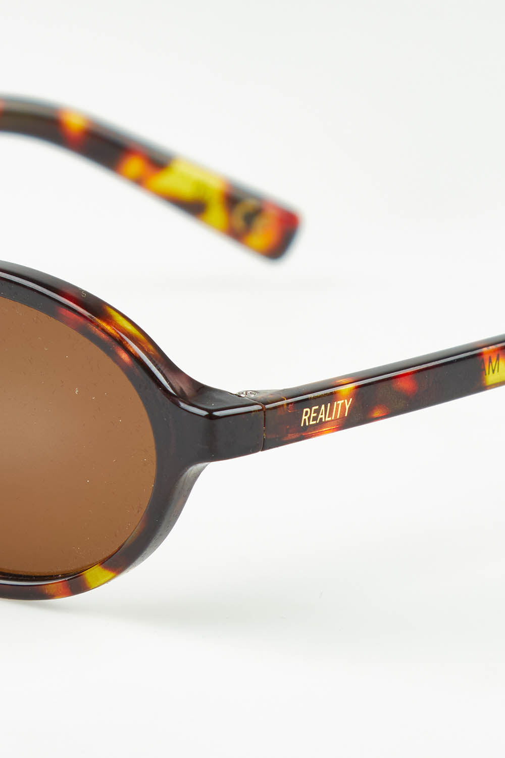 A model wearing The Bessette Sunglasses in colour Turtlebrwn, from the front, showing the whole outfit
