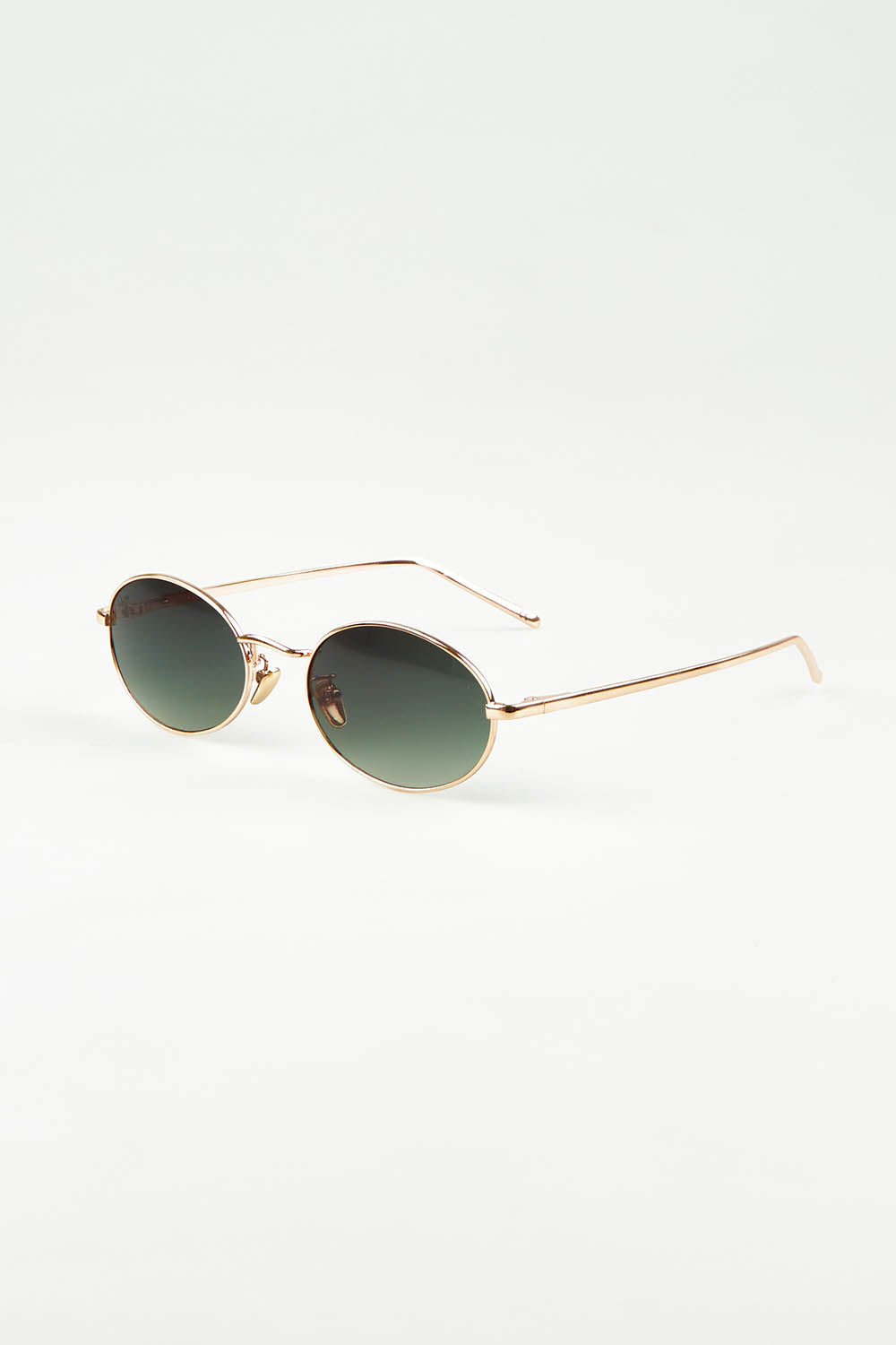 A model wearing the Helsinki Sunglasses in colour Goldgreen (Metallics), from the front, showing the whole outfit