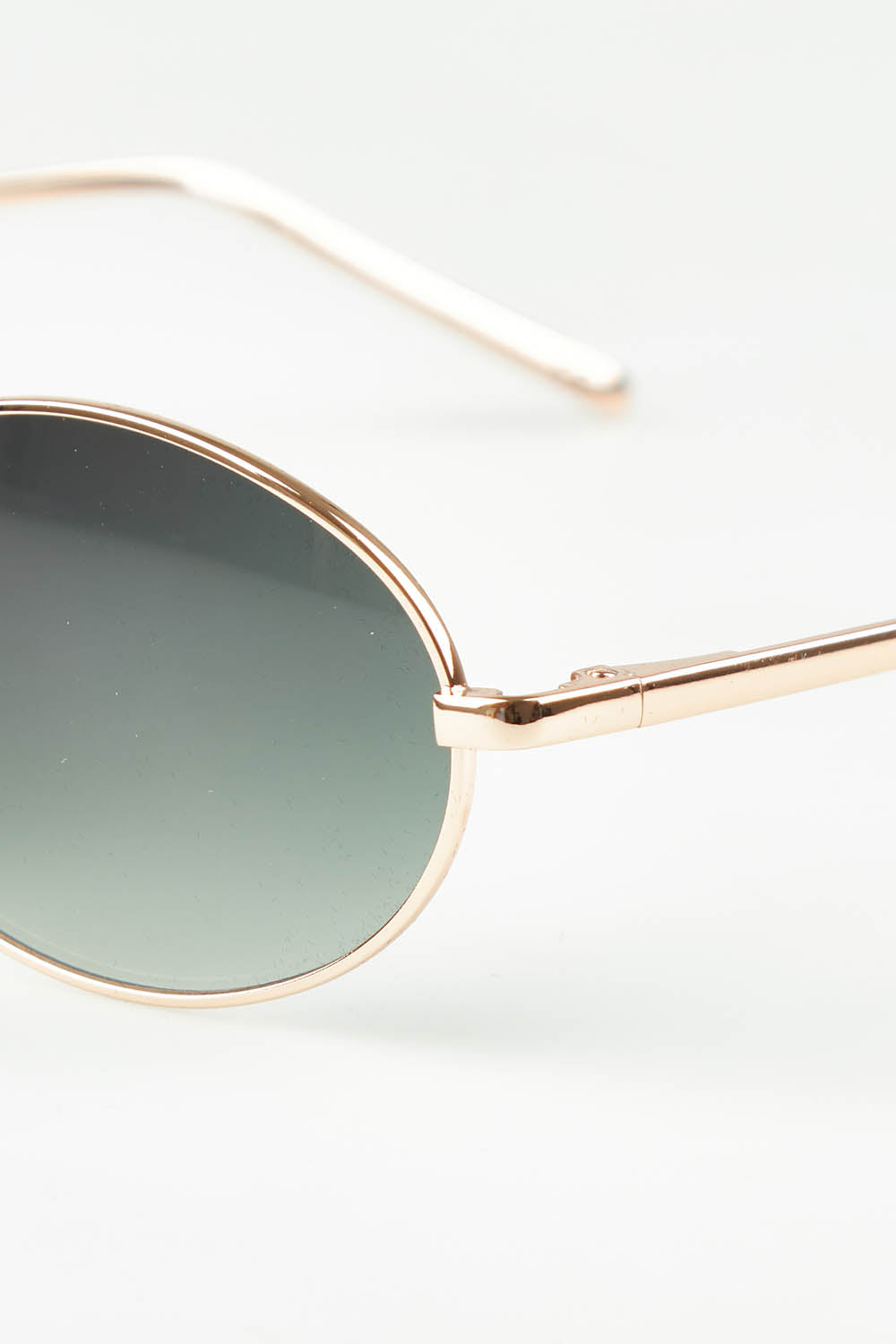 A model wearing the Helsinki Sunglasses in colour Goldgreen (Metallics), from the front, showing the whole outfit