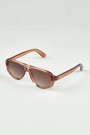 A model wearing the Ryder Sunglasses in colour Champagne, from the front, showing the whole outfit