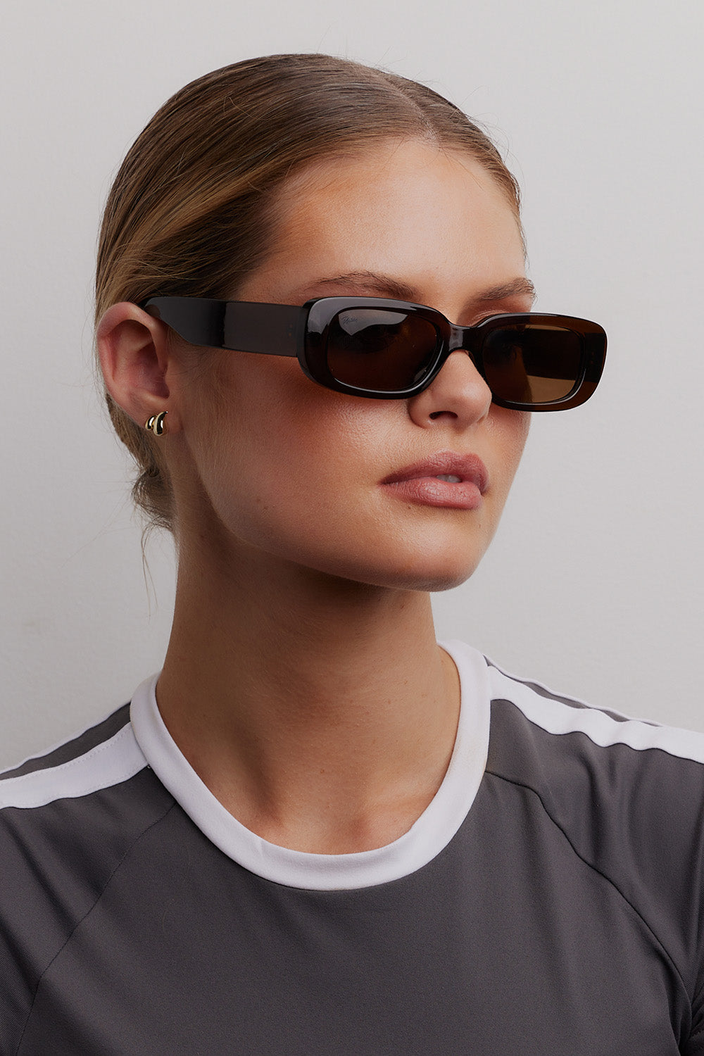 A model wearing the Xray Spex Sunglasses in colour Chocolate, from the front, cropped image