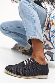 A model wearing the Derby Dream Flat in colour Blackspot (Black), from the front, cropped image