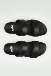 A model wearing size 37 of the Tide Leather Double Strap Slide in colour Black (Black), from the front, showing the whole outfit
