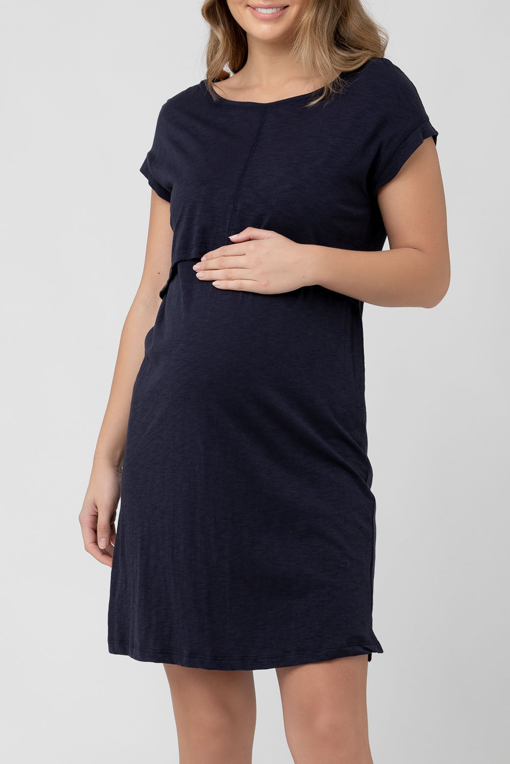 A model wearing the Roxie Nursing Dress in colour Navy (Blue), from the front, cropped image
