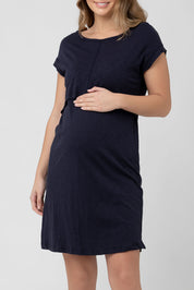 A model wearing the Roxie Nursing Dress in colour Navy (Blue), from the front, cropped image