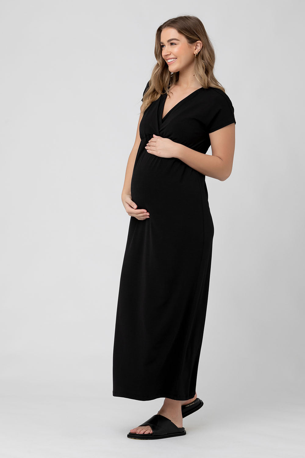 A model wearing the Misha Nursing Dress in colour Black (Black), from the front, showing the whole outfit