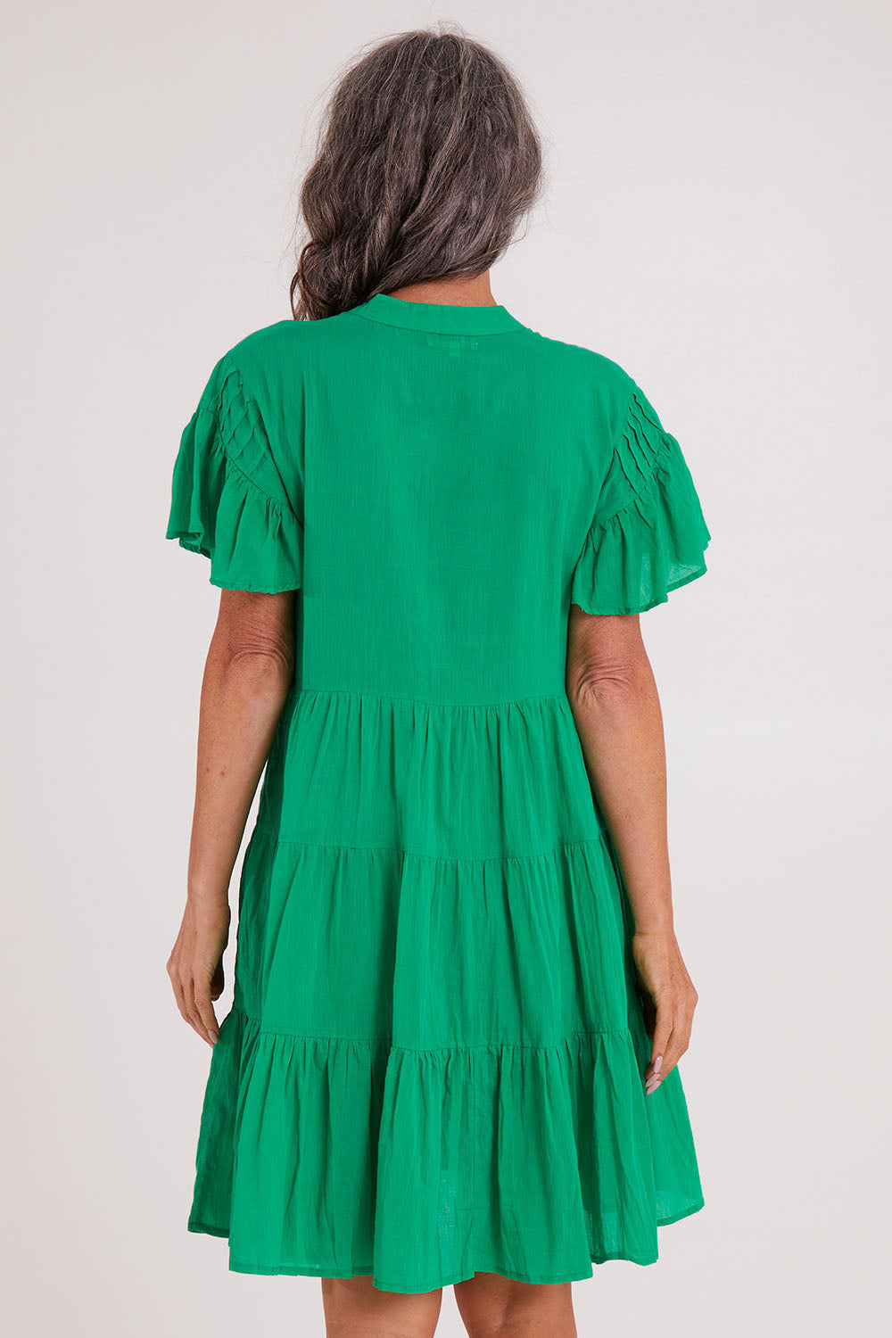 Model Luisa wearing size S of the Abigail Dress in colour Emerald (Green), from the back