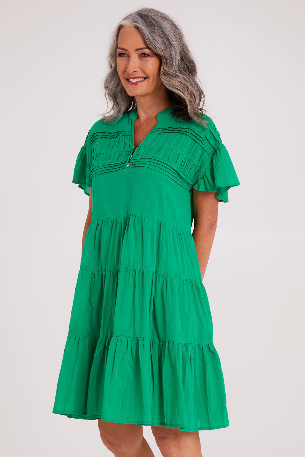 Model Luisa wearing size S of the Abigail Dress in colour Emerald (Green), from the front, cropped image
