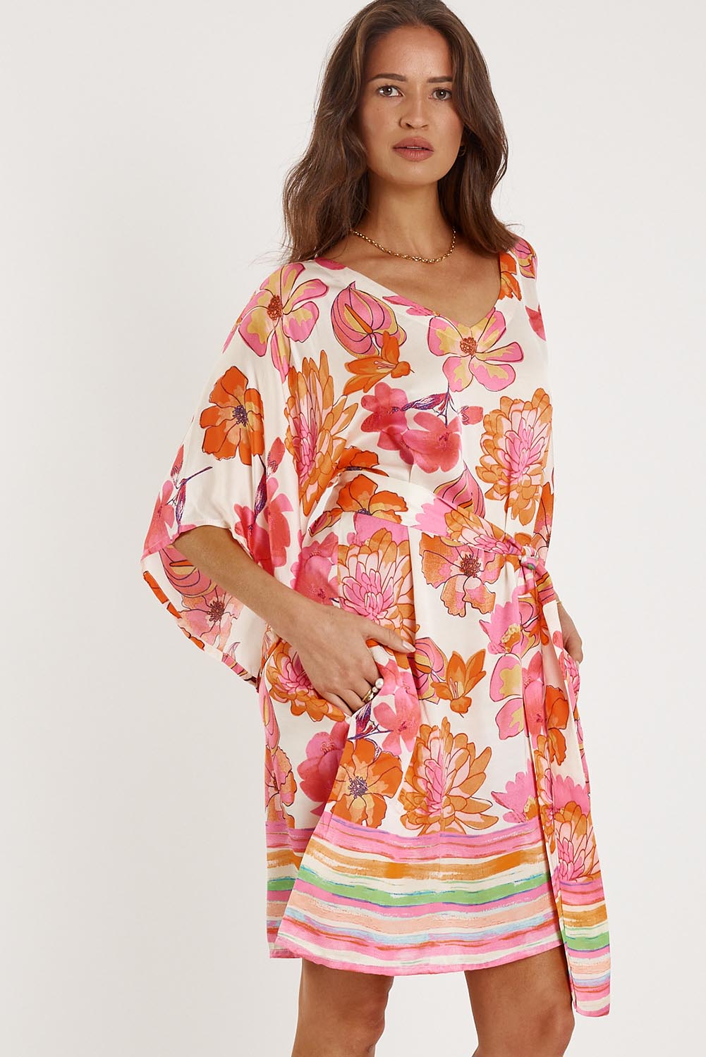 A model wearing the Sunrise Dress in colour Pink (Pink), from the front, cropped image