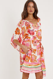 A model wearing the Sunrise Dress in colour Pink (Pink), from the front, cropped image