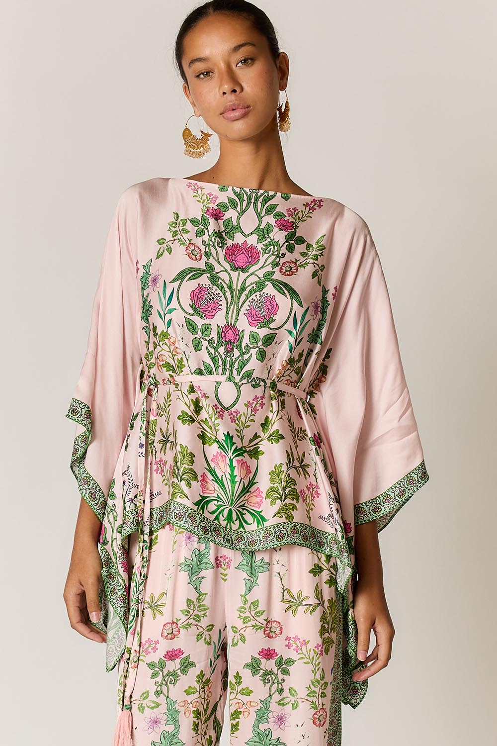 Model Genericm wearing size sample of the Tatiana Poncho – Pink in colour Pink, in a cropped view