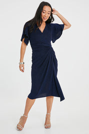 Model Katie wearing size 10 of the Emporium Dress in colour Sapphire (Blue), from the front, showing the whole outfit