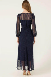 A model wearing the Sierra Wrap Dress in colour Navysparkl (Blue), from the back
