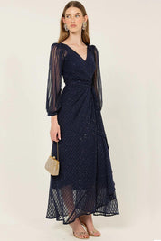 A model wearing the Sierra Wrap Dress in colour Navysparkl (Blue), from the front, showing the whole outfit
