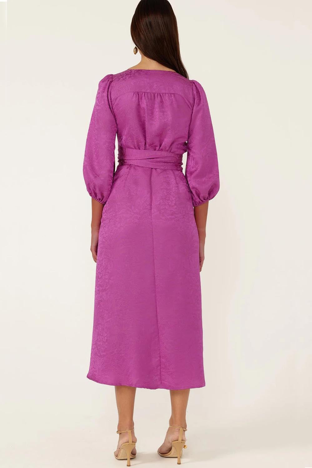 A model wearing the Chateau Wrap Dress in colour Magenta (Pink), from the back