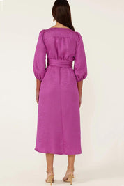 A model wearing the Chateau Wrap Dress in colour Magenta (Pink), from the back