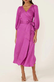 A model wearing the Chateau Wrap Dress in colour Magenta (Pink), from the front, cropped image