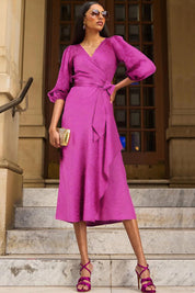 A model wearing the Chateau Wrap Dress in colour Magenta (Pink), from the front, showing the whole outfit