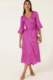 A model wearing the Chateau Wrap Dress in colour Magenta (Pink), from the front, showing the whole outfit