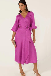 A model wearing the Chateau Wrap Dress in colour Magenta (Pink), from the front, showing the whole outfit