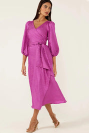 A model wearing the Chateau Wrap Dress in colour Magenta (Pink), from the front, showing the whole outfit