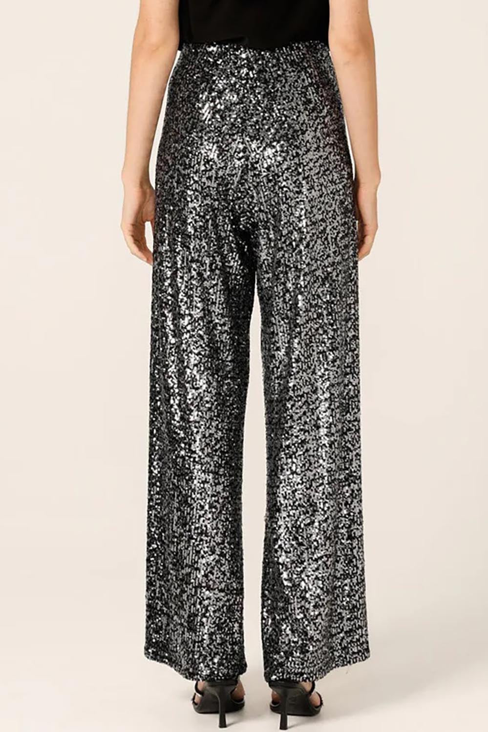 A model wearing the Sequin Palazzo Pants in colour Blksilver (Black), from the back