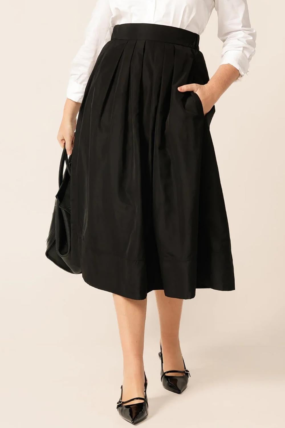 A model wearing the Pleated Ain colourLine Skirt - Black (Black), from the front, cropped image