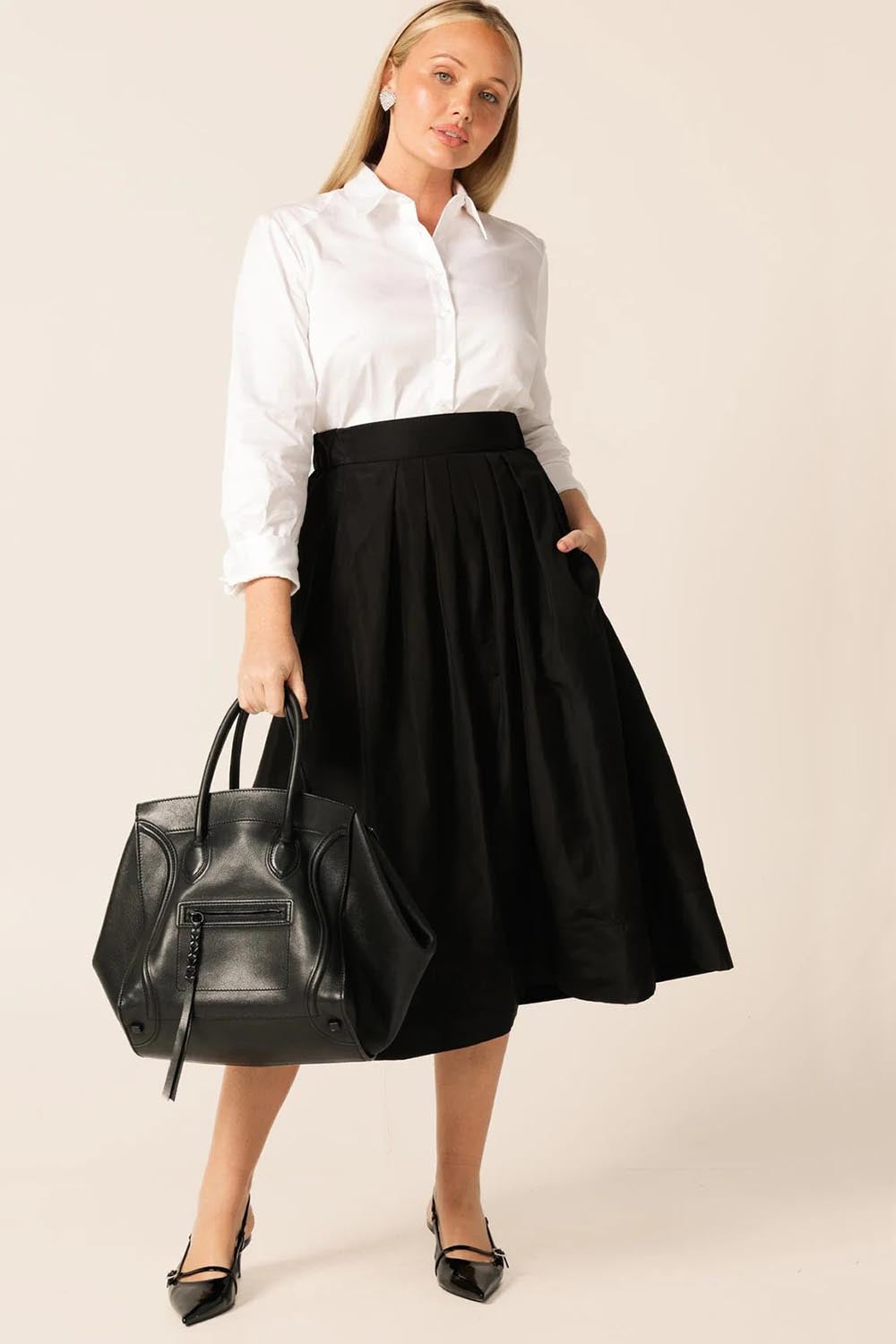 A model wearing the Pleated Ain colourLine Skirt - Black (Black), from the front, showing the whole outfit