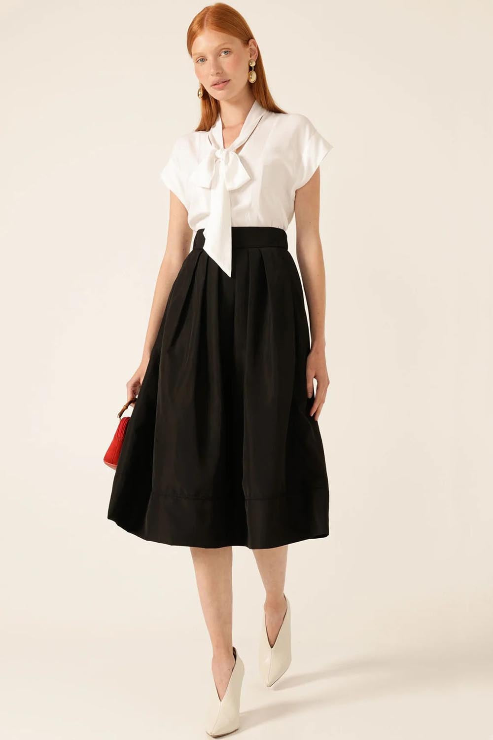A model wearing the Pleated Ain colourLine Skirt - Black (Black), from the front, showing the whole outfit