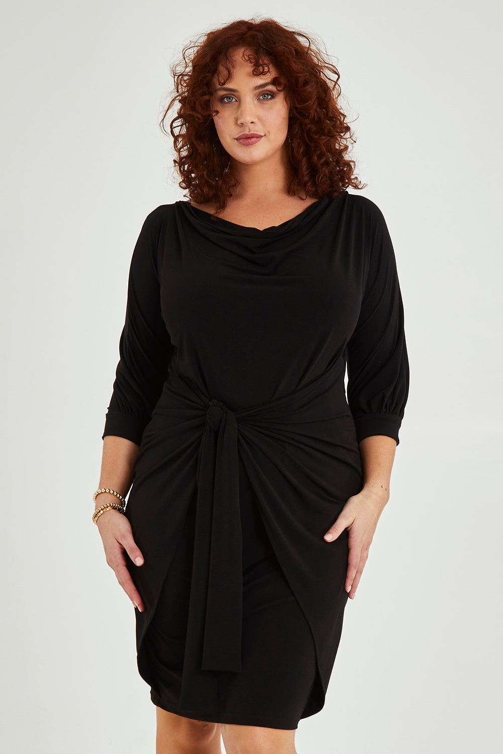 Model Maddy wearing size 16 of the Cowl Tie Drape Dress in colour Black (Black), from the front, cropped image