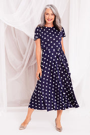Model Luisa wearing size 10 of the Reverse Wrap Midi Fluted Sleeve Dress in colour Polka (Blue), from the front, showing the whole outfit