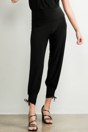 A model wearing the Harem Pant in colour Black (Black), from the front, cropped image