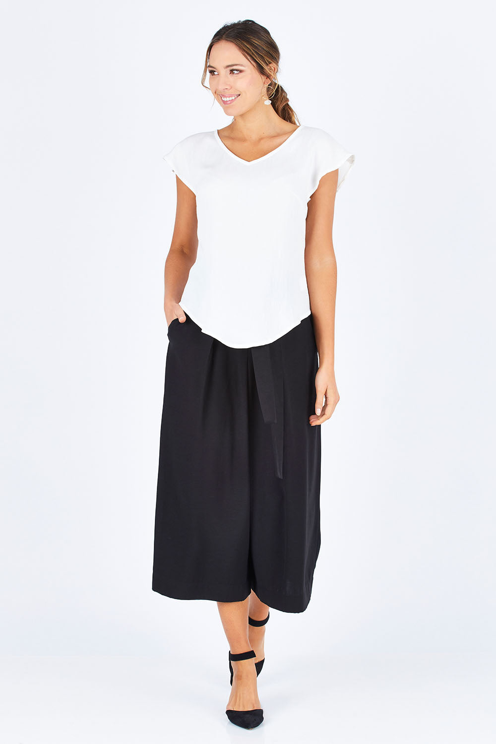 Model Madeline wearing size 10 of the Analia Top in colour White (White), from the front, showing the whole outfit