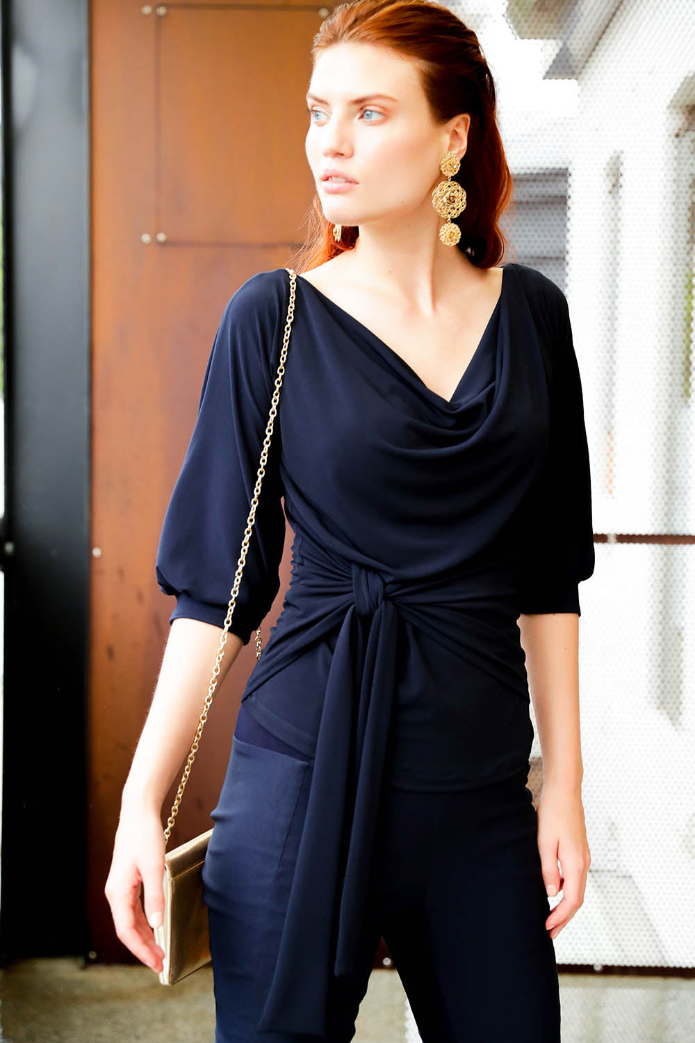 A model wearing the Cowl Tie Top in colour Navy (Blue), from the front, showing the whole outfit