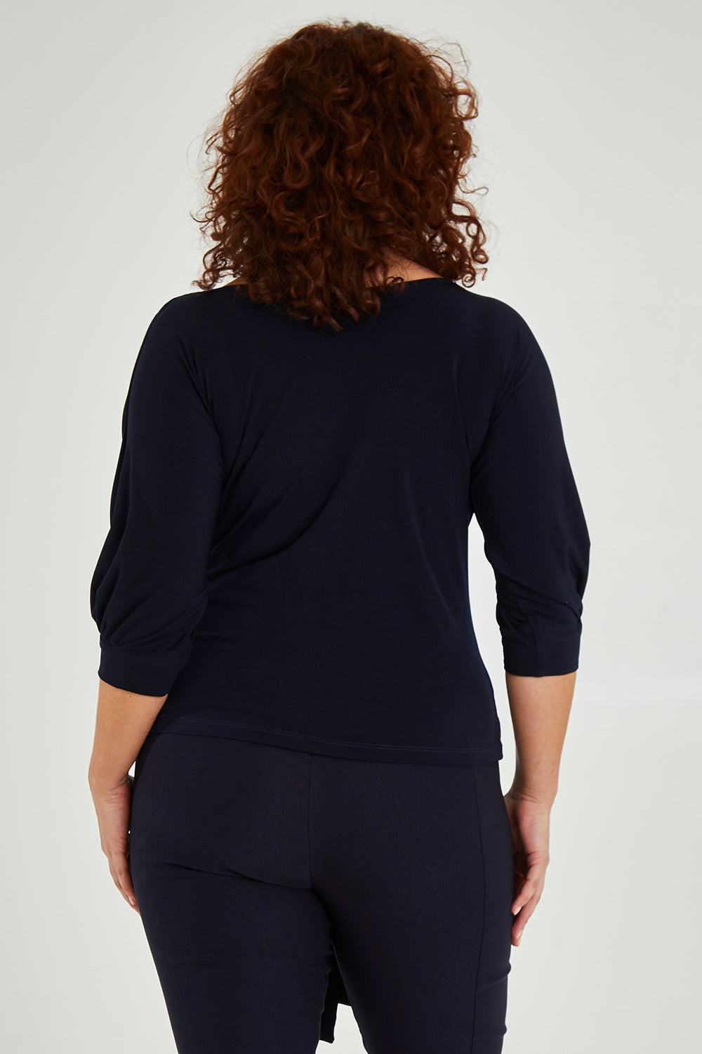 Model Maddy wearing size 16 of the Cowl Tie Top in colour Navy (Blue), from the back
