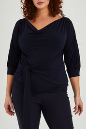 Model Maddy wearing size 16 of the Cowl Tie Top in colour Navy (Blue), from the front, cropped image