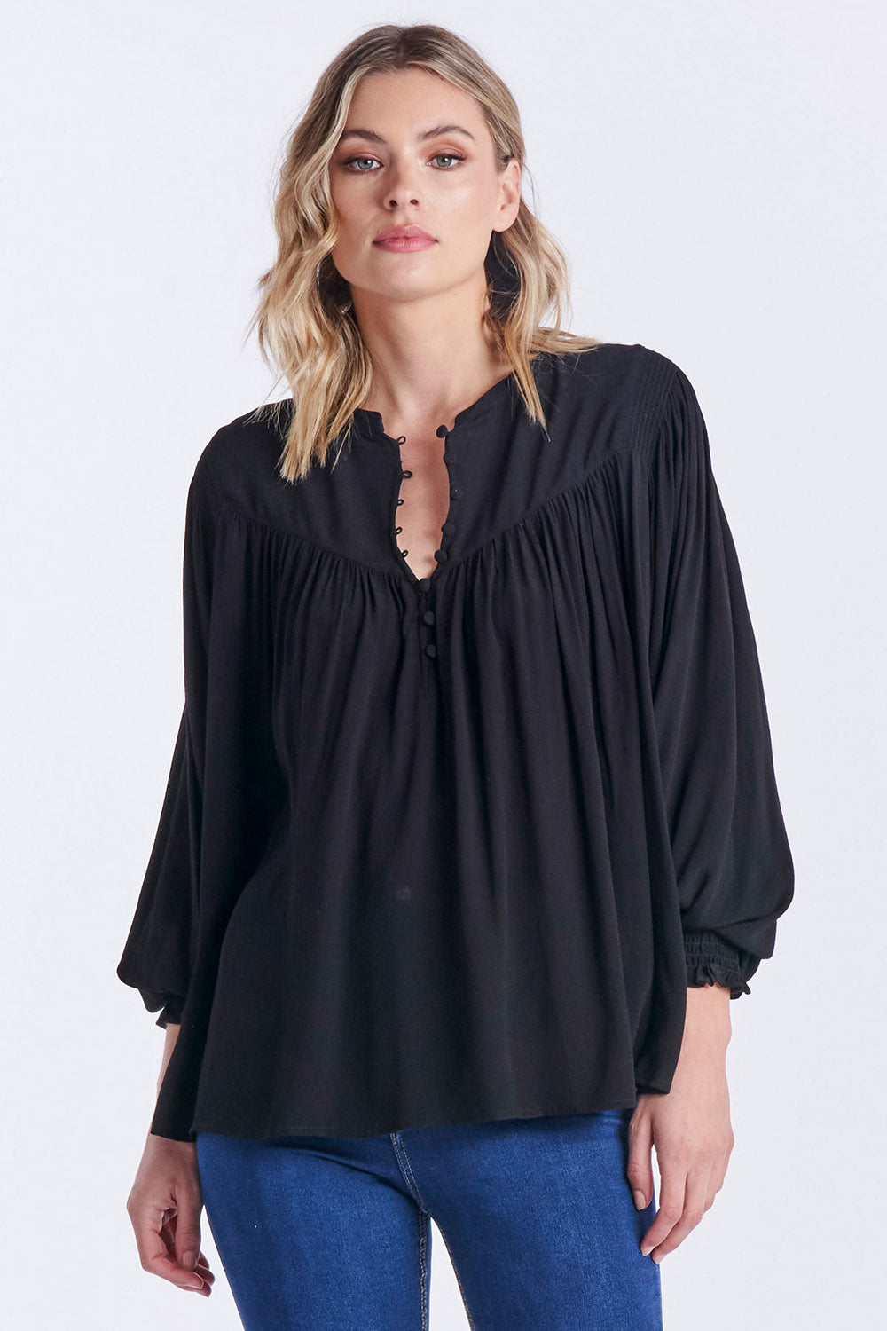 A model wearing the Susanna Top in colour Black (Black), from the front, cropped image