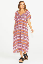 A model wearing the Raquel Midi Dress in colour Aztec (Pink), from the front, showing the whole outfit