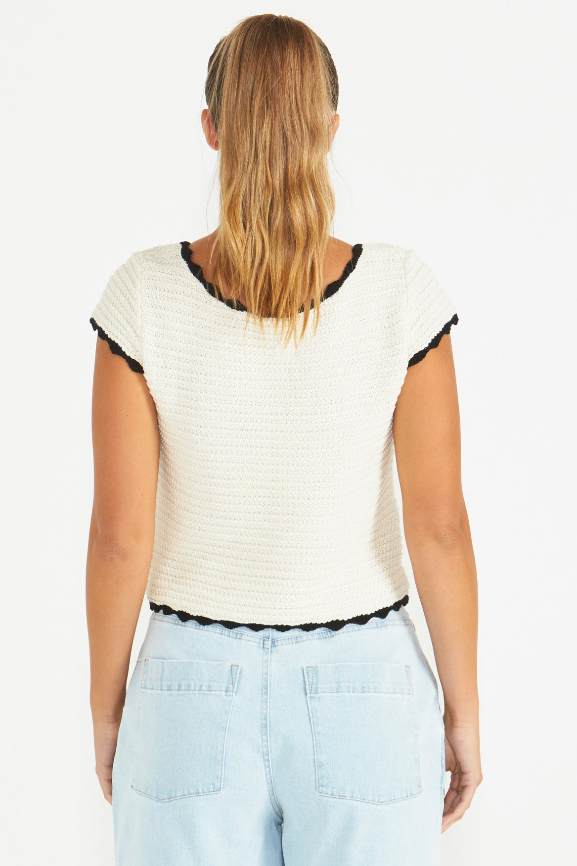 A model wearing the Coco Crochet Cotton Knit Top in colour Cream, from the back