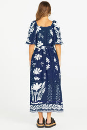 A model wearing the Lyndel Dress in colour Navy (Blue), from the back