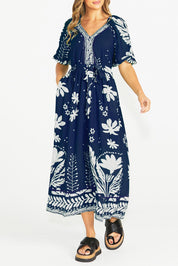 A model wearing the Lyndel Dress in colour Navy (Blue), from the front, cropped image