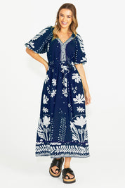A model wearing the Lyndel Dress in colour Navy (Blue), from the front, showing the whole outfit